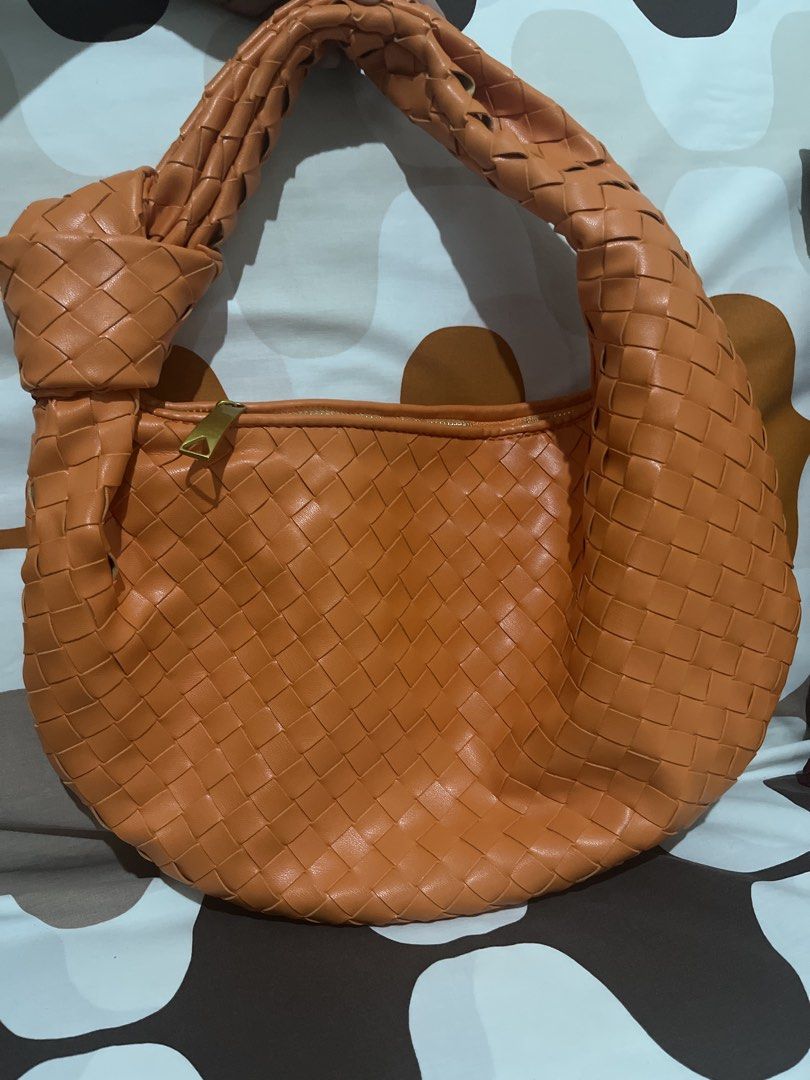 Orange Woven Shoulder Bag with Knot Handle (Category: Shoulder Bags) located in Las Pinas. Submitted by erenrosc (Listing ID 1466082067, Image 2). Description: - Color/Material: Bright orange woven faux leather - Design: Unique knotted handle on one side - Hardware & Closure: Gold-tone hardware with secure top zip closure - Interior: Spacious matching lining with an extra zippered pocket - Condition: Clean overall, great statement piece for daily