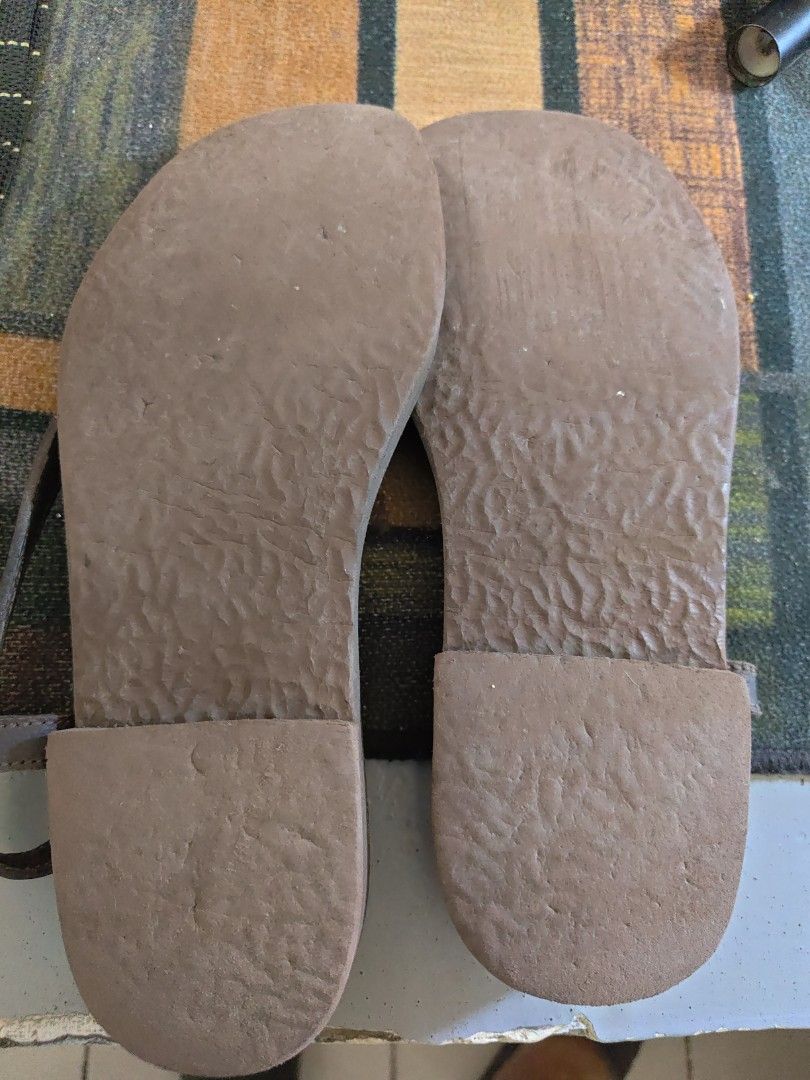 Our Tribe Brown Leather Sandals Size 70 (Category: Flats & Sandals) located in Las Pinas. Submitted by Kariicature (Listing ID 1465966967, Image 2). Description: - Brand: Our Tribe - Style: Leather thong sandals with slingback strap and buckle adjustment - Size: Marked 70 (fits women's US 7) - Color: Dark brown - Features: Distinct bull logo stamped near the heel, textured rubber soles for extra grip - Condition: Pre-loved, well-maintained buyer 