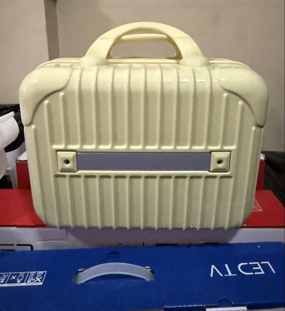 Pale Yellow Hard Shell Cosmetic Vanity Case (Category: Purses & Pouches) located in Imus. Submitted by silentfire-353921 (Listing ID 1465969115, Image 1). Description: - Color: Pale yellow - Material: Hard shell with vertical ribbed exterior - Closure: Zip-around with top carry handle - Interior: Lined with black fabric - Organization: Zippered mesh pocket on upper lid flap and deep main compartment - Condition: Clean and ready for use - Ideal fo