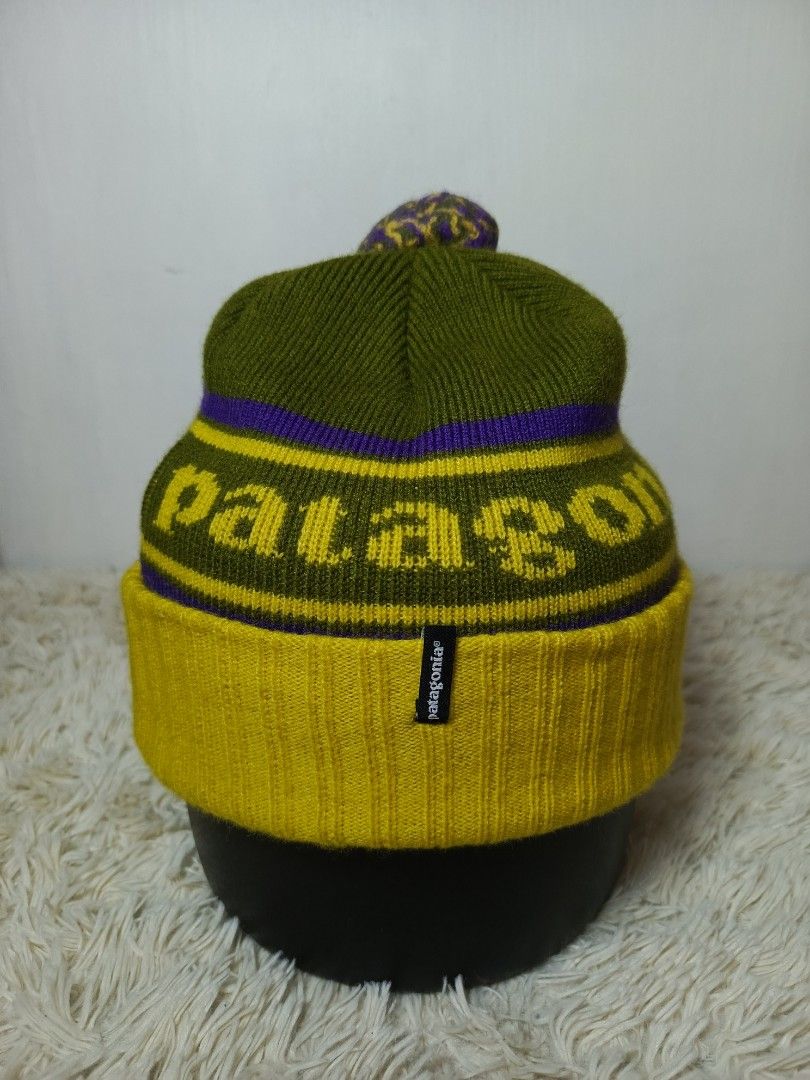 PATAGONIA POM POM BENNIE (Category: Caps & Hats) located in Baguio. Submitted by 074thriftmania (Listing ID 1466116376, Image 1). Description: - Brand: Patagonia - Style: Winter beanie with pom pom - Colorway: Olive green body with yellow/purple stripes and text - Details: Thick ribbed yellow fold-over cuff with front black logo label - Material: Warm, high-quality knit for cold weather - Condition: Brand new / Excellent (ready to ship) OSFA .