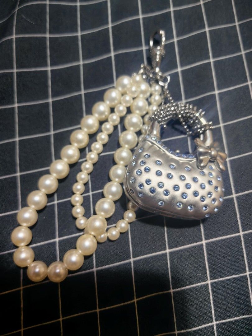 Pearl and Rhinestone Handbag Charm with Strap (Category: Charms) located in Davao. Submitted by thefrugalshop (Listing ID 1466087795, Image 1). Description: - Y2K aesthetic silver mini handbag charm - Covered in sparkly blue rhinestones with a cute side bow accent - Textured handle and multi-strand faux pearl strap in varying bead sizes - Convenient clip hook at the top for bags, keys, or accessories - Brand new and ready to ship!.