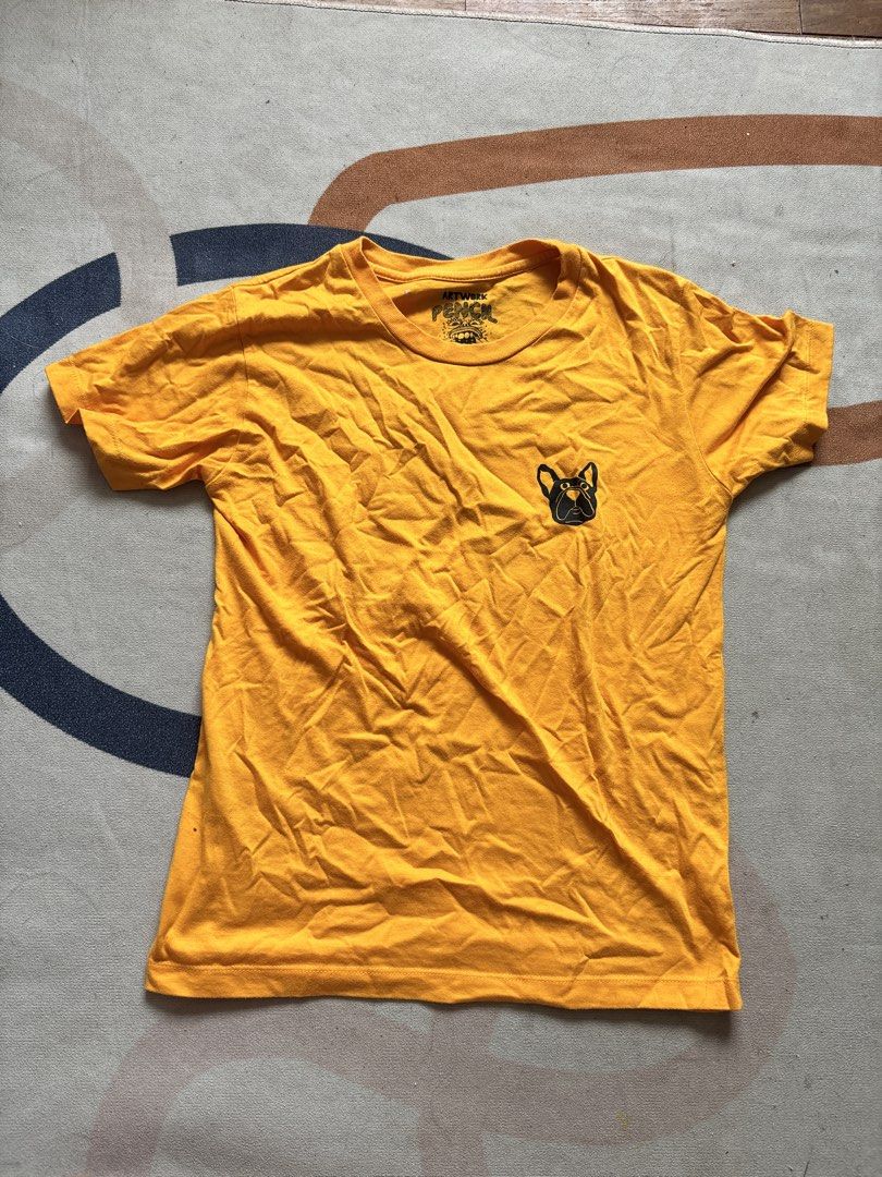 Pencil Eaters Yellow T-shirt Medium (Category: Tshirts & Polo Shirts ) located in Taguig. Submitted by narulover (Listing ID 1465980903, Image 1). Description: - Brand: Pencil Eaters - Size: Medium - Color: Bright yellow - Fit: Standard fit with short sleeves - Design: Small bulldog graphic on left chest - Special Detail: Unique interior neck print and branding - Condition: Casual staple piece in vibrant, eye-catching color.
