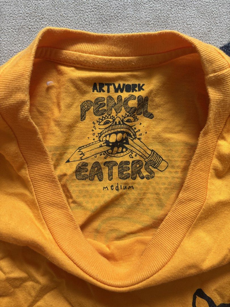 Pencil Eaters Yellow T-shirt Medium (Category: Tshirts & Polo Shirts ) located in Taguig. Submitted by narulover (Listing ID 1465980903, Image 2). Description: - Brand: Pencil Eaters - Size: Medium - Color: Bright yellow - Fit: Standard fit with short sleeves - Design: Small bulldog graphic on left chest - Special Detail: Unique interior neck print and branding - Condition: Casual staple piece in vibrant, eye-catching color.