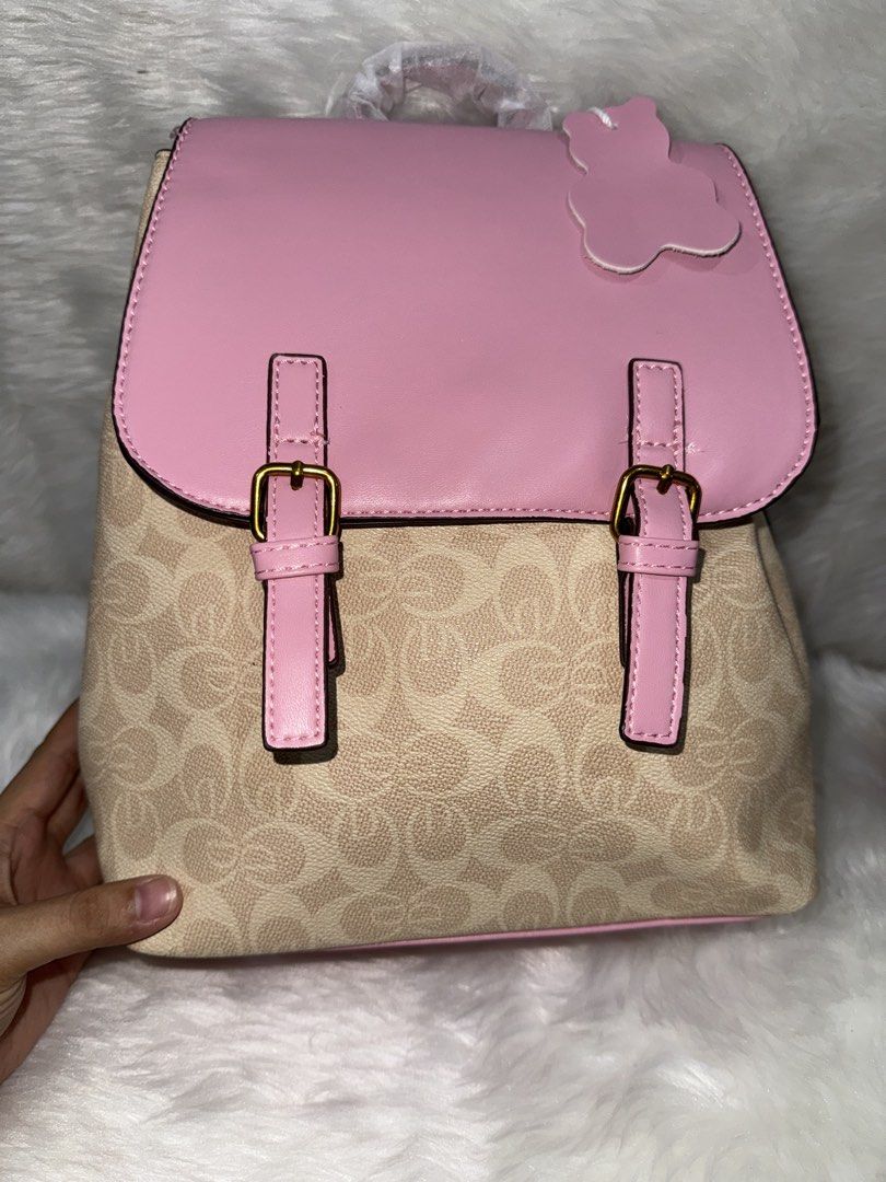 Pink beige monogram leather backpack with flap closure (Category: Backpacks) located in Taguig. Submitted by roseanneramirez (Listing ID 1466026754, Image 1). Description: - Stylish pink and beige all-over monogram pattern - Solid pink leather top flap with dual vertical buckle straps - Elegant gold-tone hardware details - Comes with a cute detachable bear-shaped charm - Top handle still wrapped in original protective plastic - Structured shape w