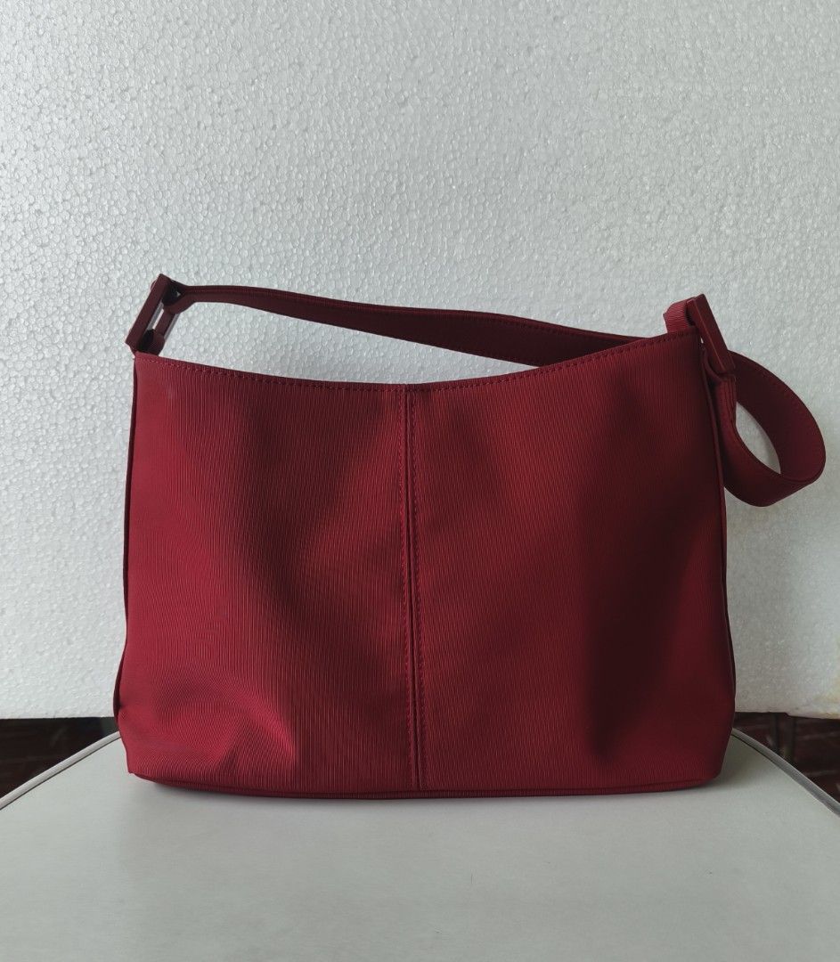 Pink Nylon Shoulder Bag with Magnetic Snap Closure (Category: Shoulder Bags) located in San Juan City. Submitted by vingabby (Listing ID 1465964543, Image 2). Description: - Color/Material: durable nylon maroon - Closure: Secure magnetic snap - Storage: Main compartment with an interior zippered pocket - Strap:shoulder strap - Interior: Clean lining featuring a visible brand logo patch.