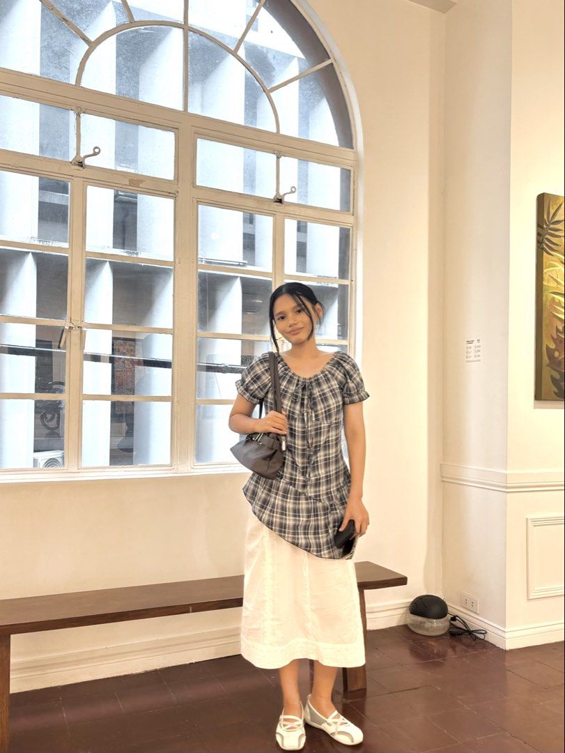Plaid Short-Sleeve Blouse with Drawstring Neckline (Category: Blouses) located in Manila. Submitted by pureforest_68db5f (Listing ID 1466075214, Image 2). Description: - Grey and white plaid blouse - Lightweight and breathable 100% cotton fabric - Short puff sleeves with cute ruffled cuffs - Adjustable drawstring neckline - Trendy asymmetrical hemline (longer on the left) - Versatile piece, easy to pair with skirts or denim.