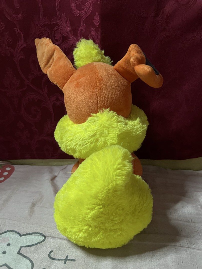 Pokemon Flareon Plush Toy (Category: Plushies & Soft Toys) located in Bulacan. Submitted by haven_plushie_dolls.888 (Listing ID 1466080296, Image 2). Description: - Official Pokémon Flareon plush toy - Soft orange fabric with vibrant yellow fluff on neck and tail - Large pointy ears with dark inner details - Sits upright independently - Includes original yellow hang tag and white tush tag - Clean and well-maintained collector's item.