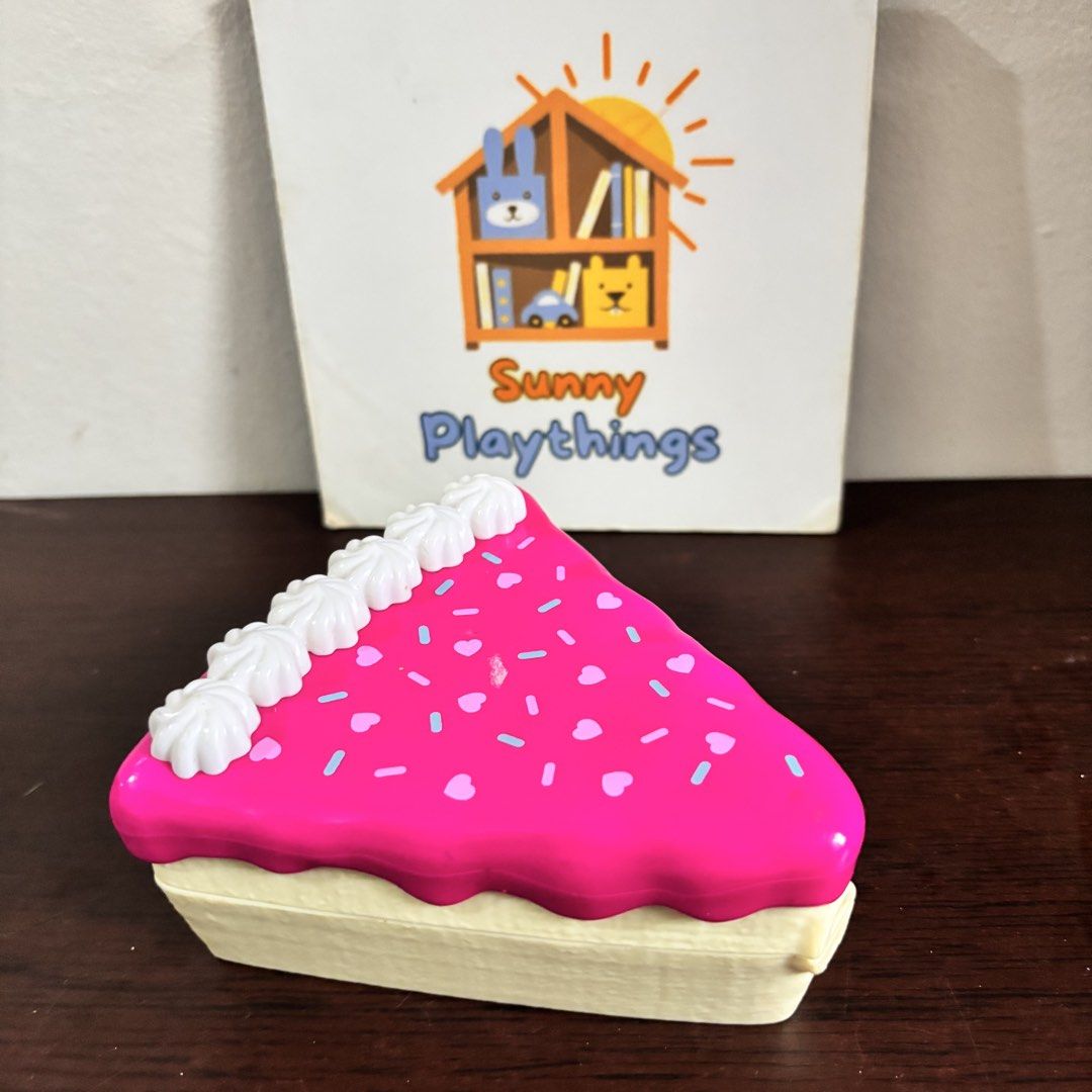 Polly Pocket (Category: Kids Toys) located in Taguig. Submitted by sunnyplaythingsph (Listing ID 1466086114, Image 1). Description: Pink cake slice playset that opens up into a mini party room. Includes one mini doll with purple skirt and shirt. Inside has a DJ booth, disco ball, stairs, merry-go-round, and purple seating area. Closes back into a cake container decorated with white icing and sprinkles on top. No lock, with tao, no basag no crack.