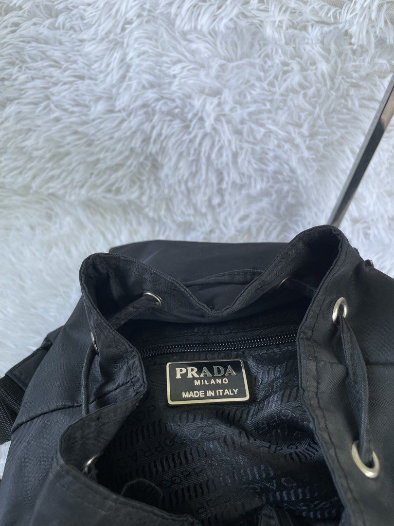 Prada Black Nylon Backpack (Category: Backpacks) located in San Carlos. Submitted by jessamaep_deer (Listing ID 1465970669, Image 3). Description: - Authentic Prada classic black nylon backpack - Sleek silver-tone hardware accents - Secure drawstring closure with buckled top flap - Two convenient front utility pockets with buckle straps - Spacious interior featuring a signature logo plaque and jacquard fabric lining - Adjustable shoulder straps a