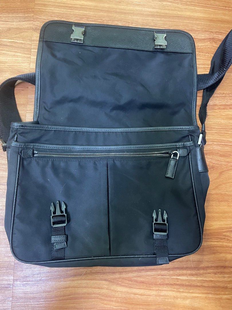 Prada Black Nylon Messenger Bag (Category: Luxury Bags & Wallets) located in Quezon City. Submitted by impulse.ph (Listing ID 1466149756, Image 2). Description: - Authentic Prada messenger bag in classic black nylon - Front flap design with secure buckle closures and convenient zip pocket underneath - Iconic Prada triangular logo plate on the front and Prada Milano metal plaque inside - Comfortable, adjustable fabric shoulder strap for daily wear
