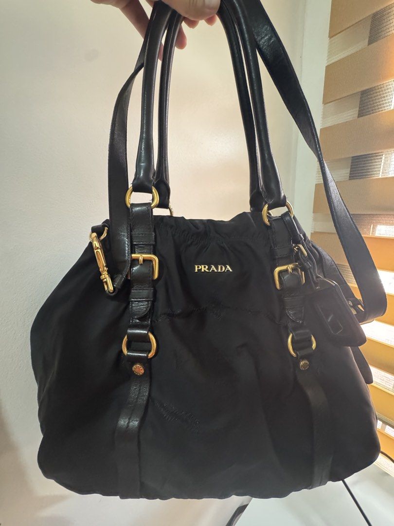 Authentic Prada Black Nylon Tote Bag with COA (Category: Luxury Bags & Wallets) located in Angeles City. Submitted by thala.1204.68 (Listing ID 1465968383, Image 1). Description: - Authentic Prada nylon tote bag in classic black/ comes with B101 Revue certificate for authenticity/100% original - comes with long strap - Elegant gold-tone hardware and metal Prada lettering logo - Double leather handles plus an adjustable shoulder strap for versatil