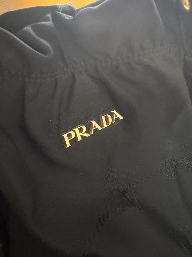 Authentic Prada Black Nylon Tote Bag with COA (Category: Luxury Bags & Wallets) located in Angeles City. Submitted by thala.1204.68 (Listing ID 1465968383, Image 2). Description: - Authentic Prada nylon tote bag in classic black/ comes with B101 Revue certificate for authenticity/100% original - comes with long strap - Elegant gold-tone hardware and metal Prada lettering logo - Double leather handles plus an adjustable shoulder strap for versatil
