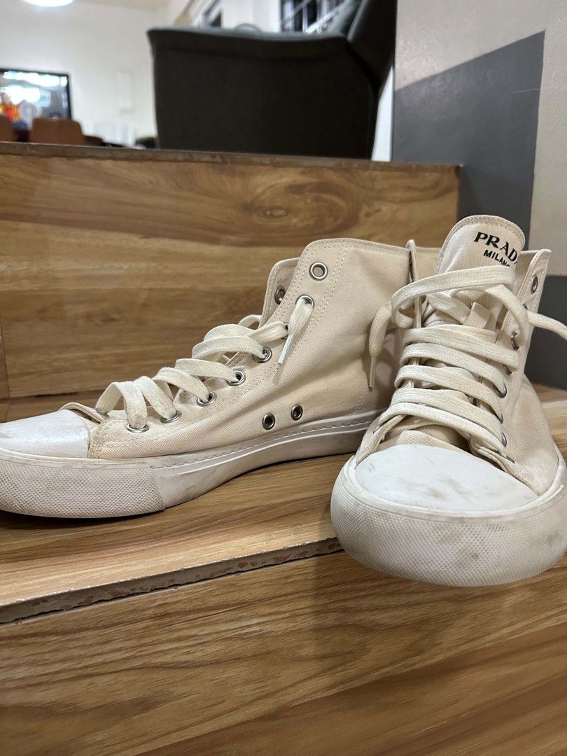 Prada Milano High-Top Canvas Sneakers Off-White (Category: Sneakers) located in Balanga. Submitted by dbg13 (Listing ID 1466097978, Image 3). Description: - Brand: Prada Milano - Style: Off-white canvas high-top sneakers - Details: Lace-up closure with silver-tone eyelets, classic cap toe, and embossed Prada logo on the heel counter - Color: Neutral off-white that goes with any outfit - Condition: Worn a few times, with some light scuffs on the t