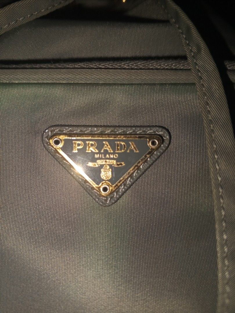 Prada Nylon Bucket Bag (Category: Luxury Bags & Wallets) located in Magalang. Submitted by zeiansoria64090 (Listing ID 1466083605, Image 2). Description: - Authentic Prada nylon bucket bag - Features a convenient top handle and secure drawstring closure - Front zipper pocket accented with the iconic metal triangle logo - Luxurious gold-tone hardware, including Lampo zippers and engraved handle rings - Spacious interior with practical compartments