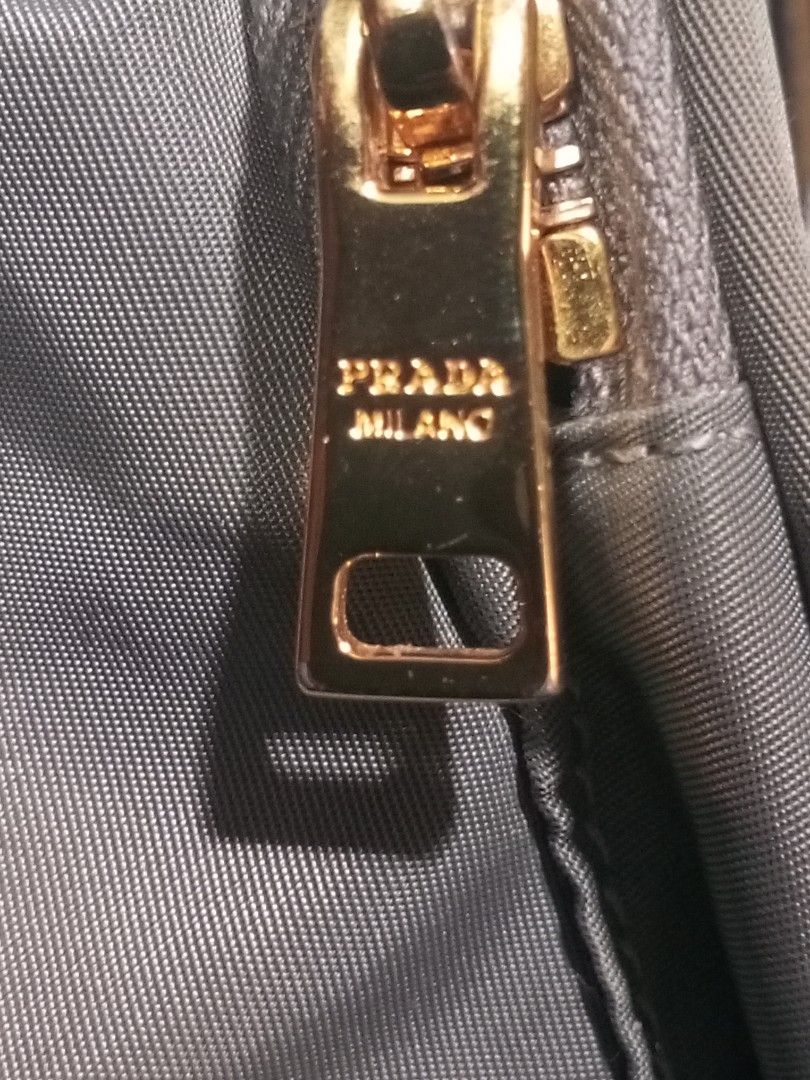 Prada Nylon Bucket Bag (Category: Luxury Bags & Wallets) located in Magalang. Submitted by zeiansoria64090 (Listing ID 1466083605, Image 3). Description: - Authentic Prada nylon bucket bag - Features a convenient top handle and secure drawstring closure - Front zipper pocket accented with the iconic metal triangle logo - Luxurious gold-tone hardware, including Lampo zippers and engraved handle rings - Spacious interior with practical compartments