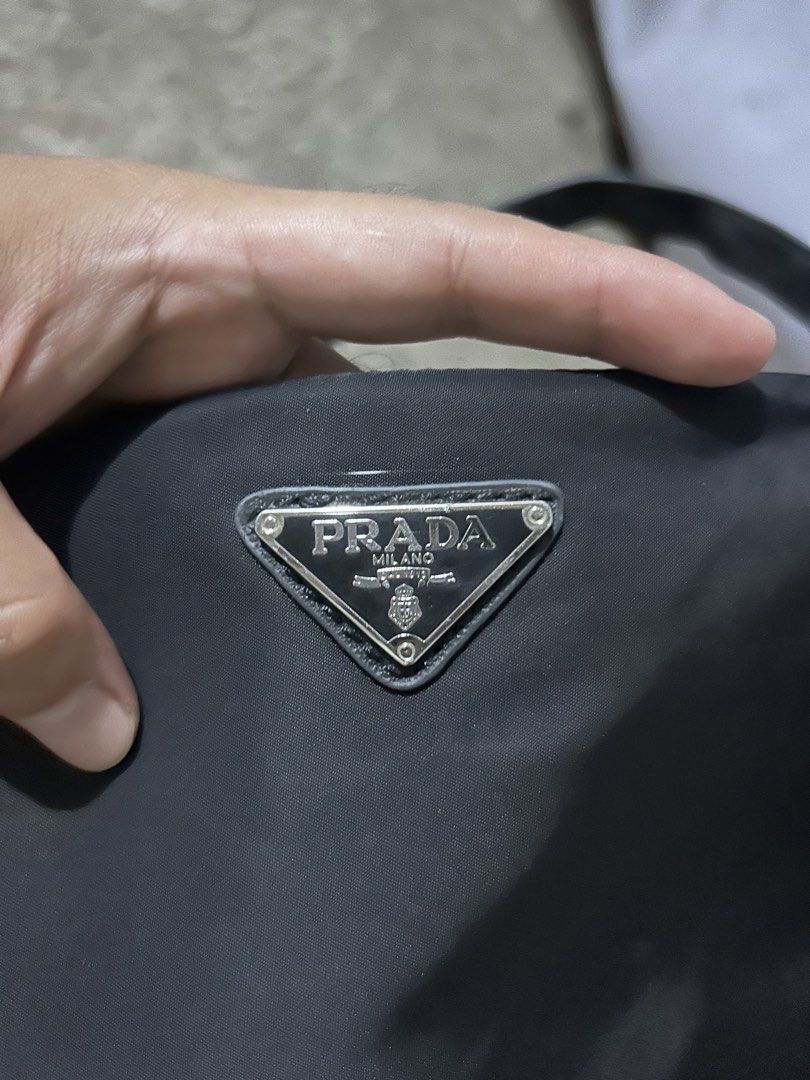 Prada Nylon Mini Shoulder Bag Black (Category: Luxury Bags & Wallets) located in Barotac Nuevo. Submitted by ehsherjohn27 (Listing ID 1466047678, Image 2). Description: - Authentic vintage Prada black nylon shoulder bag - Silver-tone hardware with iconic enamel triangle logo plaque - Signature jacquard fabric interior lining with a convenient zipper pocket - Single adjustable strap featuring a stylish buckle detail - Classic silhouette with plent