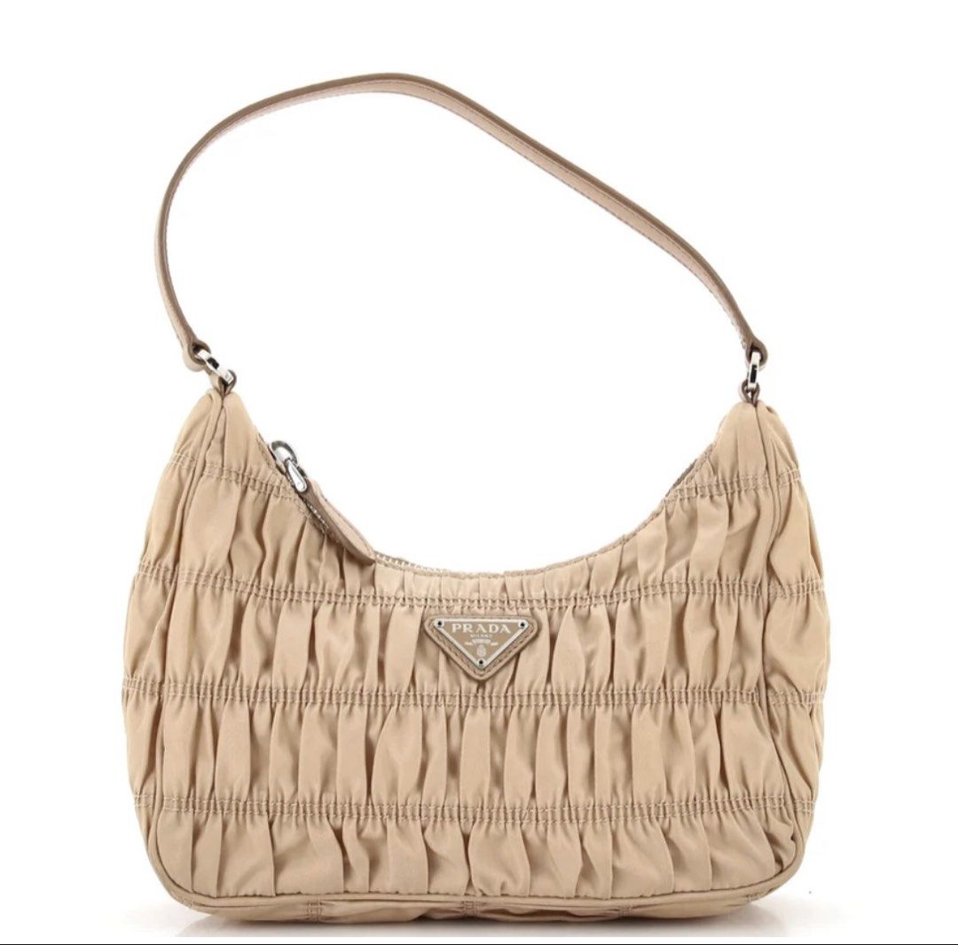Prada Ruched Nylon Shoulder Bag Beige (Category: Luxury Bags & Wallets) located in Cauayan City . Submitted by espiritucj (Listing ID 1465984650, Image 1). Description: Thrifted Pc. -Prada shoulder bag in a chic beige ruched nylon design - Features durable Saffiano leather strap and sleek silver-tone hardware - Secure top zip closure for your daily essentials - Signature jacquard lining throughout the interior - Includes interior Prada logo plaqu