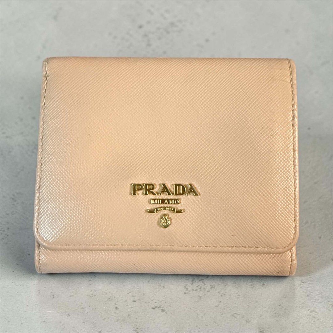 Prada Saffiano Leather Compact Wallet in Beige (Category: Luxury Bags & Wallets) located in Manila. Submitted by attypreciousyzncpa (Listing ID 1466150093, Image 1). Description: - Brand: Prada - Material: Premium Saffiano leather in a versatile beige shade - Hardware: Elegant gold-toned metal logo lettering - Design: Structured foldover with a durable, scratch-resistant finish - Size: Compact and pocket-friendly, ideal for everyday use and small