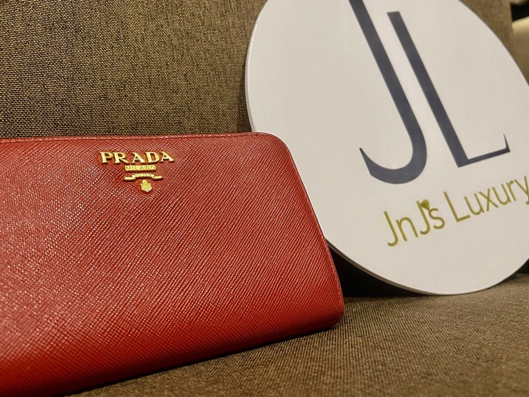 Prada Saffiano Metal Red Zip Around Wallet (Category: Wallets & Card holders) located in Manila. Submitted by jnjsluxury (Listing ID 1465960656, Image 1). Description: - Authentic Prada zip-around wallet in vibrant red Saffiano leather - gold-tone hardware featuring the classic Prada Milano logo - Organized interior with multiple card slots, bill compartments, and a secure zipped coin pocket - Pristine and well-maintained condition for both inter