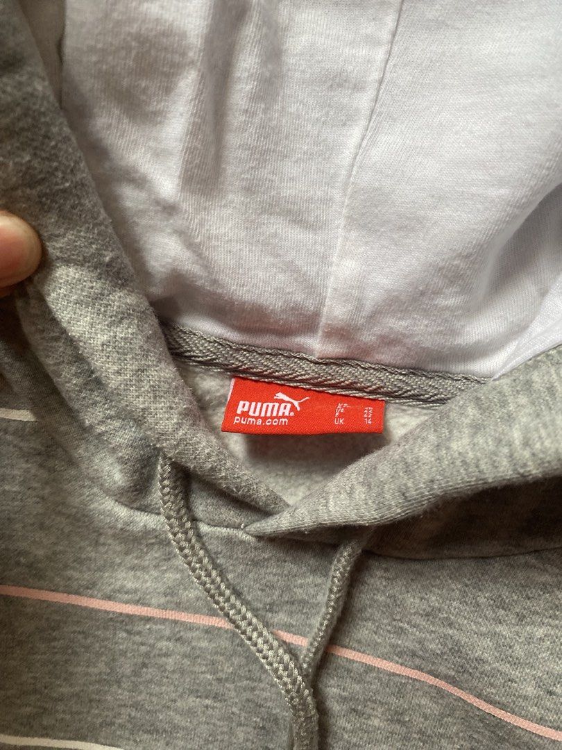 Puma Striped Grey Hoodie (Category: Coats, Jackets and Outerwear) located in Tanauan. Submitted by rie098 (Listing ID 1466040408, Image 3). Description: - Brand: Puma - Style: Grey hoodie with horizontal pink and white stripes - Size: UK 14 - Material: 80% cotton, 20% polyester (Made in Malaysia) - Features: Drawstring hood with white lining, front kangaroo pocket, and embroidered chest logo - Condition: Excellent / Pre-loved (ready to wear).