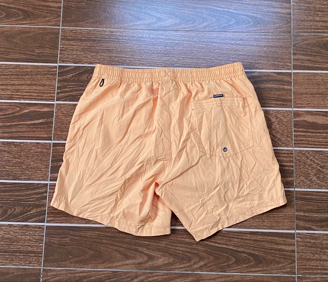 QUIKSILVER (Category: Swim Trunks & Board Shorts) located in Cebu City. Submitted by thriftpherskzai (Listing ID 1466074473, Image 3). Description: - Brand: Quiksilver - Color: Vibrant peach orange - Waistband: Comfortable elastic with adjustable white drawstring - Storage: Convenient back pocket with embroidered logo label - Details: Iconic mountain and wave patch near the bottom hem - Material: Lightweight fabric, ideal for swimming and beach d