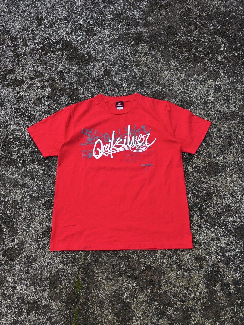 Quiksilver Red Graphic T-Shirt (Category: Tshirts & Polo Shirts ) located in Caloocan City. Submitted by elpotato (Listing ID 1466009822, Image 1). Description: - Brand: Quiksilver - Color: Bright red - Fit: Classic crew neck with short sleeves - Design: Large graphic text on chest and small logo on back shoulder - Condition: Clean fabric with vibrant color throughout - Style: Casual streetwear.