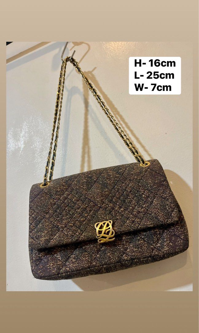 Quilted Chain Shoulder Bag with Gold Clasp (Category: Luxury Bags & Wallets) located in Bacolod City. Submitted by vintage_vogue6100 (Listing ID 1463380400, Image 1). Description: - Stylish quilted shoulder bag - Textured fabric exterior - Elegant gold chain strap - Prominent gold logo clasp - Multiple interior compartments - Includes a zippered pocket - Lined with a repeating pattern - Ideal for carrying your daily essentials.