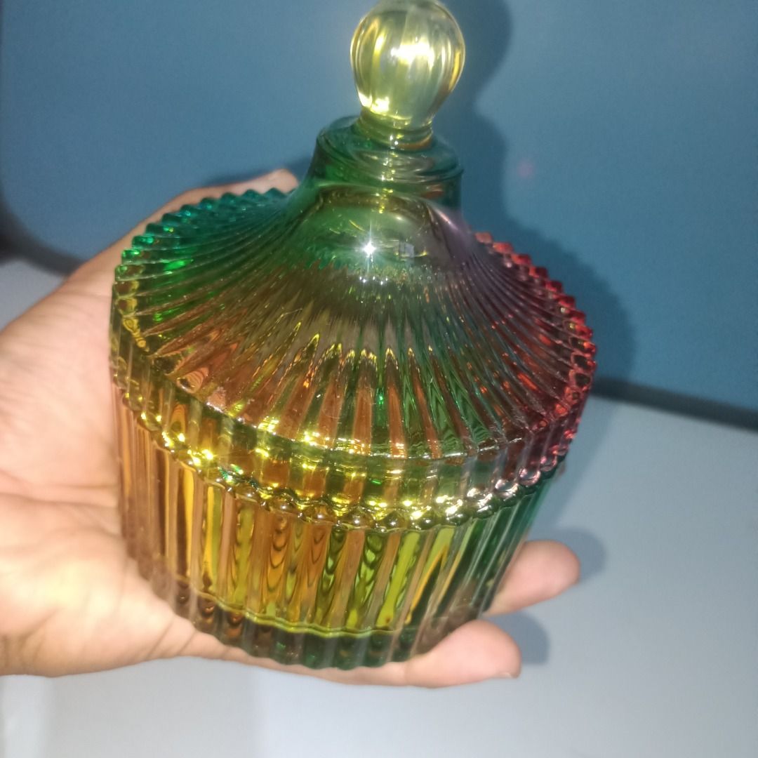 Rainbow glass candy jar with lid (Category: Food Organization & Storage) located in Munoz. Submitted by larryc1212 (Listing ID 1466113420, Image 2). Description: - Multi-colored ribbed glass jar with matching lid and round knob - Features a vibrant gradient of green, yellow, blue, and red hues - Textured vertical stripes on the translucent body and lid - Stands approximately 5 inches tall - Ideal for organizing jewelry, small trinkets, or storing