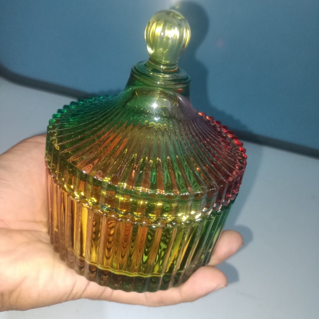 Rainbow glass candy jar with lid (Category: Food Organization & Storage) located in Munoz. Submitted by larryc1212 (Listing ID 1466113420, Image 1). Description: - Multi-colored ribbed glass jar with matching lid and round knob - Features a vibrant gradient of green, yellow, blue, and red hues - Textured vertical stripes on the translucent body and lid - Stands approximately 5 inches tall - Ideal for organizing jewelry, small trinkets, or storing
