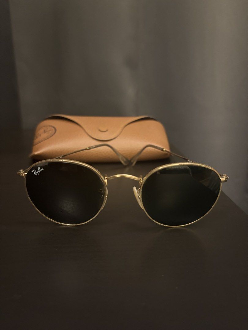 Ray-Ban Round Metal Sunglasses with Case (Category: Sunglasses & Eyewear) located in Paranaque City. Submitted by max_bully014 (Listing ID 1466091467, Image 2). Description: - Brand: Ray-Ban - Style: Classic round sunglasses with gold-tone frames - Lenses: Dark lenses in pristine condition, absolutely no scratches - Fit: Comfortable design that suits most face shapes - Inclusions: Original brown leatherette hard case with snap closure - Look: Tim