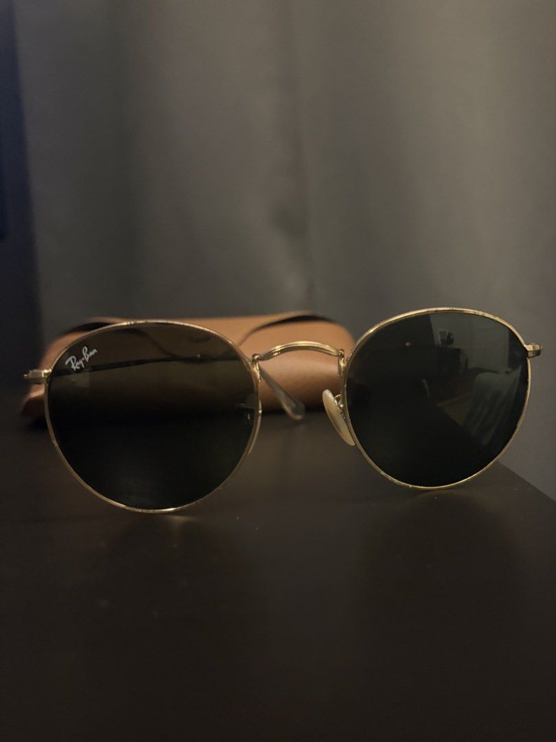 Ray-Ban Round Metal Sunglasses with Case (Category: Sunglasses & Eyewear) located in Paranaque City. Submitted by max_bully014 (Listing ID 1466091467, Image 1). Description: - Brand: Ray-Ban - Style: Classic round sunglasses with gold-tone frames - Lenses: Dark lenses in pristine condition, absolutely no scratches - Fit: Comfortable design that suits most face shapes - Inclusions: Original brown leatherette hard case with snap closure - Look: Tim