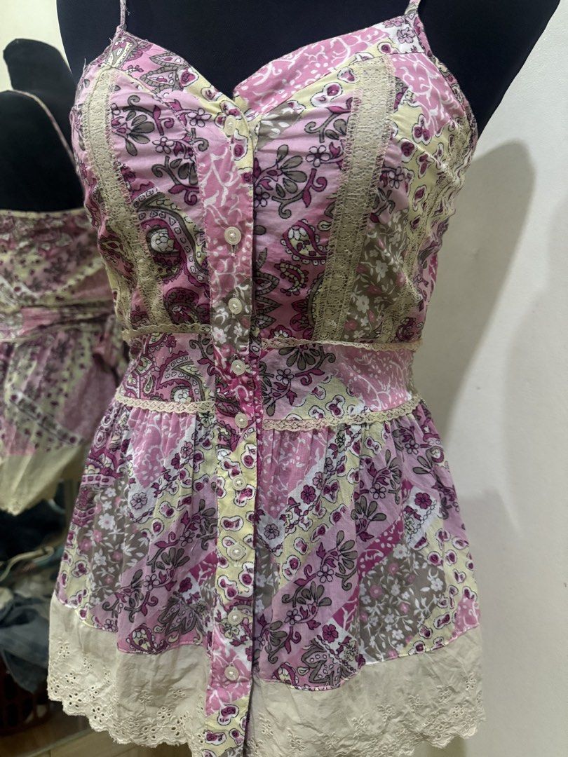 Red Camel Pink Floral Patchwork Camisole Top Size M (Category: Sleeveless) located in Cebu City. Submitted by hotchkisscebu (Listing ID 1466058529, Image 2). Description: - Brand: Red Camel - Size: M - Design: Pink patchwork floral print with delicate lace trim - Details: Spaghetti straps, front button closure, adjustable tie-back sash, and eyelet embroidery hem - Material: Lightweight and breathable, ideal for warm weather - Condition: Excellent