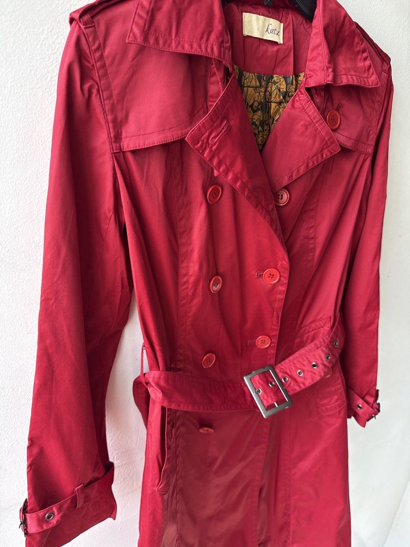 Red Double-Breasted Trench Coat with Belt (Category: Coats, Jackets and Outerwear) located in Quezon City. Submitted by dropdeadprices (Listing ID 1465998144, Image 2). Description: - Brand: Katz - Color: Red with gold patterned lining - Style: Double-breasted trench coat with mid-length cut - Details: Matching red buttons, adjustable waist belt, cuff buckle straps, shoulder epaulets, and back vent - Fabric: Lightweight and comfortable - Conditio