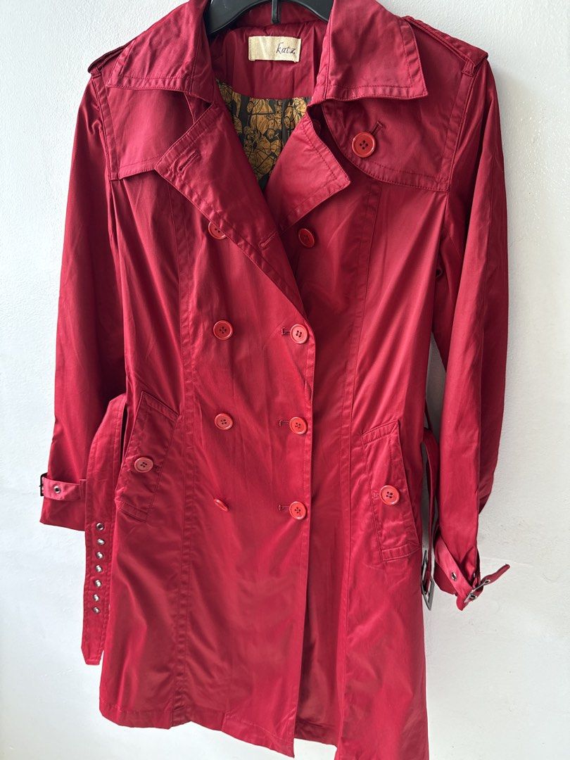Red Double-Breasted Trench Coat with Belt (Category: Coats, Jackets and Outerwear) located in Quezon City. Submitted by dropdeadprices (Listing ID 1465998144, Image 3). Description: - Brand: Katz - Color: Red with gold patterned lining - Style: Double-breasted trench coat with mid-length cut - Details: Matching red buttons, adjustable waist belt, cuff buckle straps, shoulder epaulets, and back vent - Fabric: Lightweight and comfortable - Conditio
