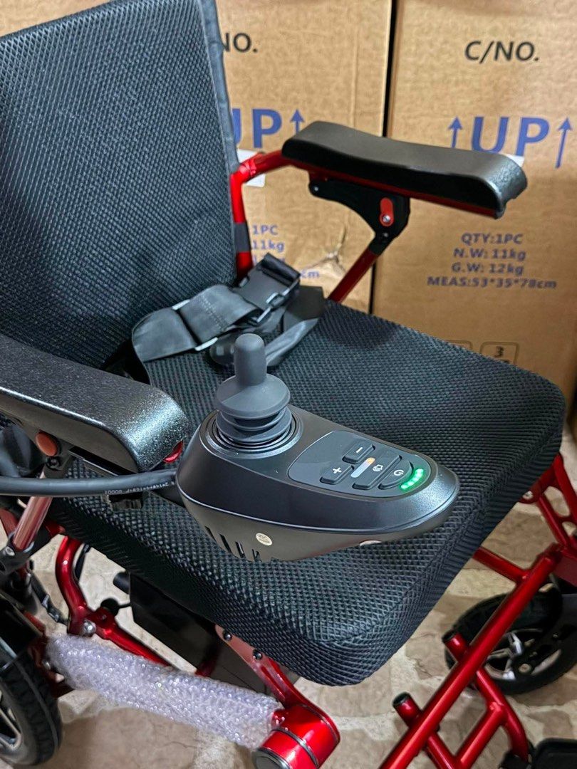 Red foldable motorized electric wheelchair with joystick (Category: Wheelchairs) located in Manila. Submitted by rosel2001 (Listing ID 1465968852, Image 3). Description: - Red foldable motorized electric wheelchair - Comfortable black mesh seat and backrest - Right-armrest joystick control with battery indicator lights - Built-in safety seat belt for secure rides - Folding footrest and solid wheels with front suspension - Compact and easy to stor