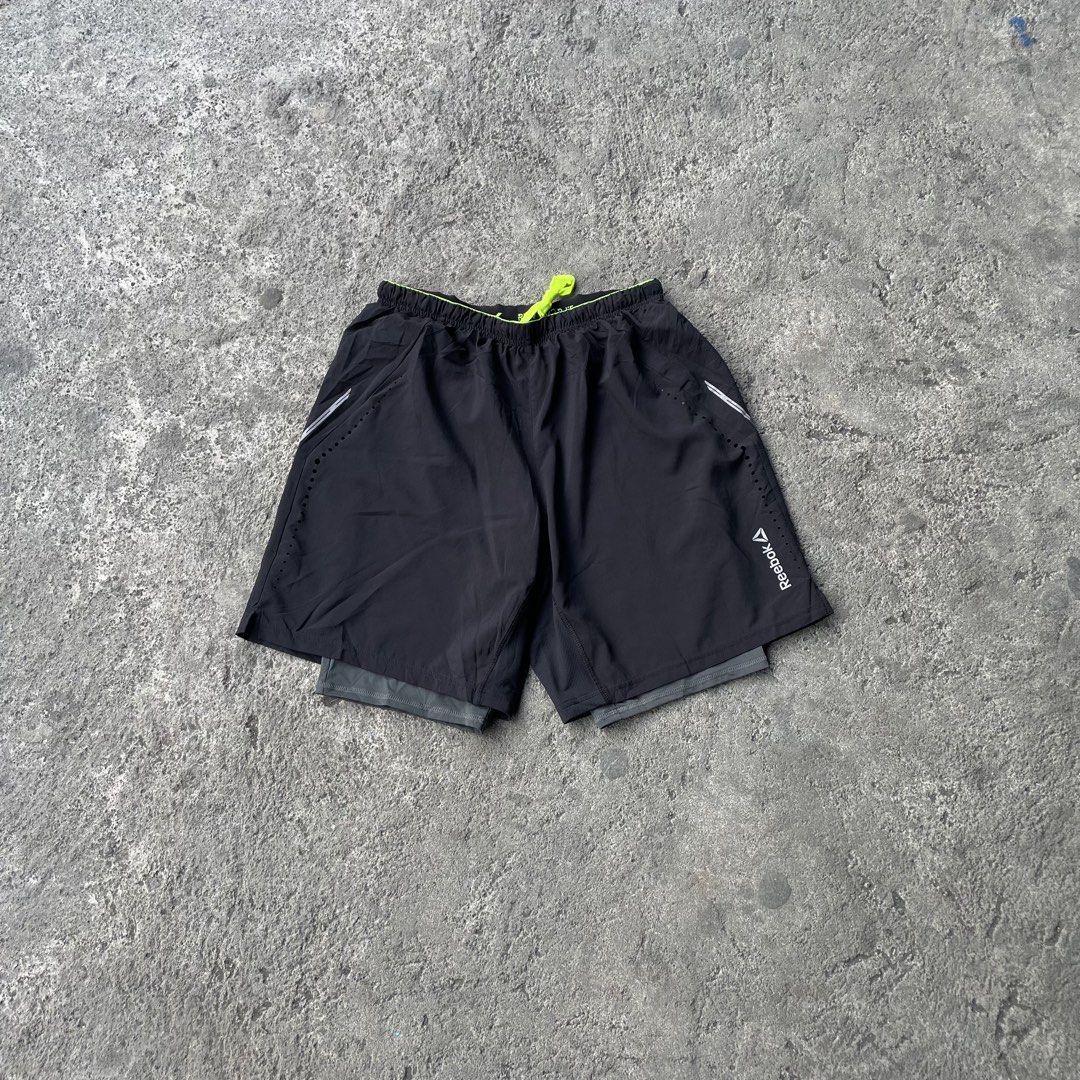 Reebok Black Running Shorts with Built-In Compression Liner (Category: Shorts) located in Polangui. Submitted by b0ssl00ts (Listing ID 1465962285, Image 1). Description: - Brand: Reebok - Color: Black with neon yellow drawstring and trim - Liner: Built-in grey compression liner for added support - Ventilation: Laser-cut side holes for maximum airflow - Details: Reflective silver accents and classic white Reebok logo on the left leg - Condition: B