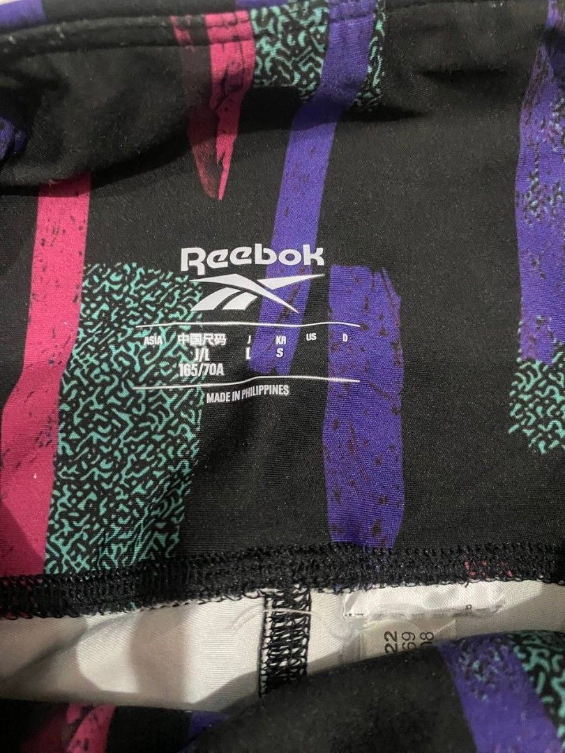 Reebok Myt allover leggings (Category: Activewear) located in Manila. Submitted by lovelypreloved1497 (Listing ID 1466103318, Image 3). Description: - Brand: Reebok - Size: US S (Made in Philippines) - Design: Bold abstract brushstroke pattern with pink, purple, and teal graphics on a black background - Fit: High-waisted with a supportive stretch band - Material: Breathable athletic fabric - Best for: Gym sessions, running, or everyday casual wea