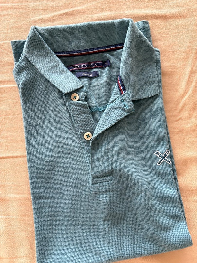 Regatta Essentials Blue Polo Shirt Size M (Category: Tshirts & Polo Shirts ) located in Quezon City. Submitted by makingroomfinds (Listing ID 1466062065, Image 1). Description: - Brand: Regatta Essentials - Style: Polo shirt with classic collar and two-button placket - Color: Blue - Size: Medium - Material: Comfortable and breathable cotton pique - Features: Short sleeves with ribbed cuffs and small embroidered logo on the chest - Condition: Grea