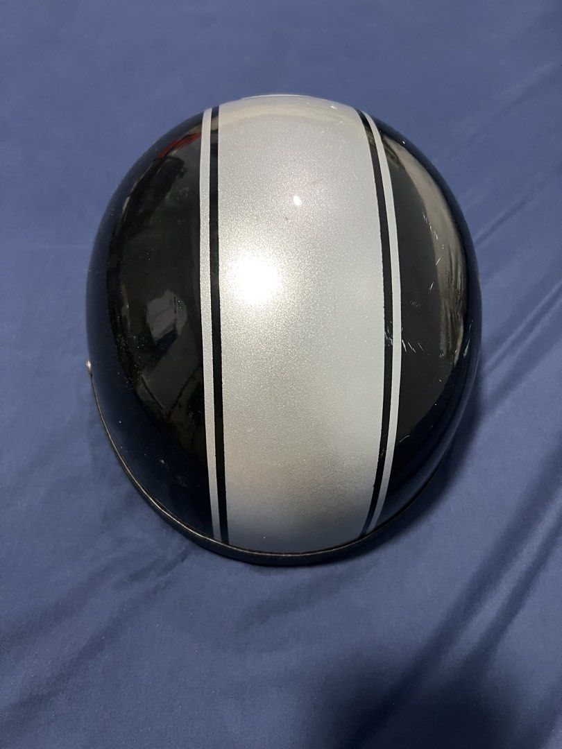Retro Black and Silver Motorcycle Half Helmet (Category: Bicycles) located in Quezon City. Submitted by swoosh24 (Listing ID 1465972114, Image 1). Description: - Style: Black helmet with striking silver racing stripe - Interior: Comfortable black leather lining with perforated metal vent buttons - Closure: Secure and reliable buckle fastening mechanism - Condition: Minor surface scuffs from previous handling.