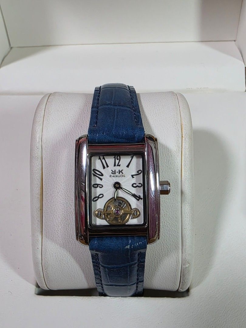 r.kikuchi Rectangular Open-Heart Watch with Blue Leather Strap (Category: Women's Watches) located in Rosales. Submitted by akumie30 (Listing ID 1466141658, Image 1). Description: - Brand/Model: R.Kikuchi rectangular watch - Dial: Textured white face with bold Arabic numerals and an open-heart mechanical movement window - Strap: Glossy blue leather with crocodile embossing - Case & Durability: Stainless steel case back with 3ATM water resistance,
