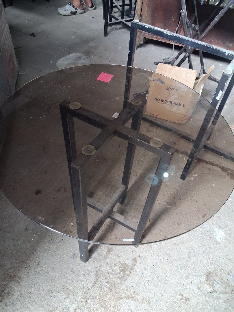 Round Glass Coffee Table with Metal Base (Category: Tables & Sets) located in Taguig. Submitted by ssvcn (Listing ID 1465974103, Image 3). Description: - Sleek round coffee table in a minimalist modern design - Smoky tint tempered glass top for a sophisticated look - Sturdy black metal frame with a stable cross-leg design - Equipped with 4 rubber suction pads to keep the glass securely in place - Perfect centerpiece for living rooms or office lou