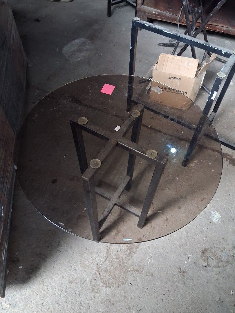 Round Glass Coffee Table with Metal Base (Category: Tables & Sets) located in Taguig. Submitted by ssvcn (Listing ID 1465974103, Image 2). Description: - Sleek round coffee table in a minimalist modern design - Smoky tint tempered glass top for a sophisticated look - Sturdy black metal frame with a stable cross-leg design - Equipped with 4 rubber suction pads to keep the glass securely in place - Perfect centerpiece for living rooms or office lou