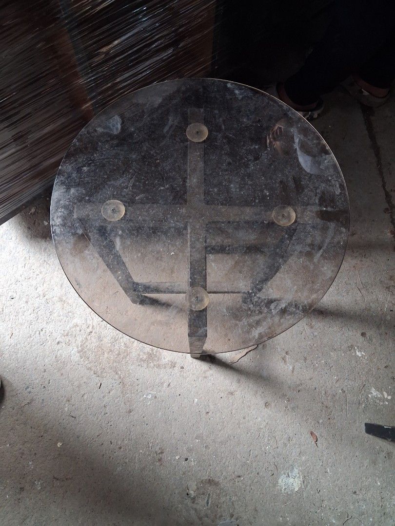 Round glass top side table with metal frame (Category: Tables & Sets) located in Taguig. Submitted by ssvcn (Listing ID 1466067200, Image 2). Description: - Heavy-duty round side table with solid metal build - Clear glass top secured by four suction cups - Sturdy X-shape metal legs for great stability - Ideal for the living room or balcony - Note: Surface has dust from storage and needs a quick clean.