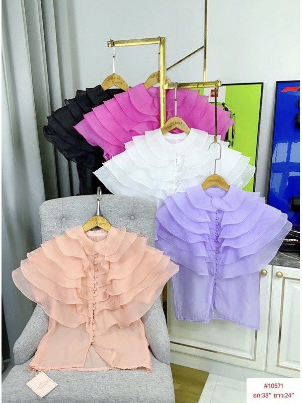 Ruffle Collar Chiffon Blouse Multiple Colors (Category: Blouses) located in Paranaque City. Submitted by jujudeclutterss (Listing ID 1466149036, Image 1). Description: - Elegant chiffon blouse with dramatic layered ruffles on collar and shoulders - Front button closure with matching round buttons - Short sleeves, lightweight, and semi-sheer fabric - Measurements: Bust 38 inches, Length 24 inches - Available colors: Peach, white, black, pink, purp