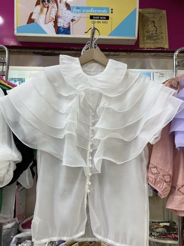 Ruffle Collar Chiffon Blouse Multiple Colors (Category: Blouses) located in Paranaque City. Submitted by jujudeclutterss (Listing ID 1466149036, Image 3). Description: - Elegant chiffon blouse with dramatic layered ruffles on collar and shoulders - Front button closure with matching round buttons - Short sleeves, lightweight, and semi-sheer fabric - Measurements: Bust 38 inches, Length 24 inches - Available colors: Peach, white, black, pink, purp