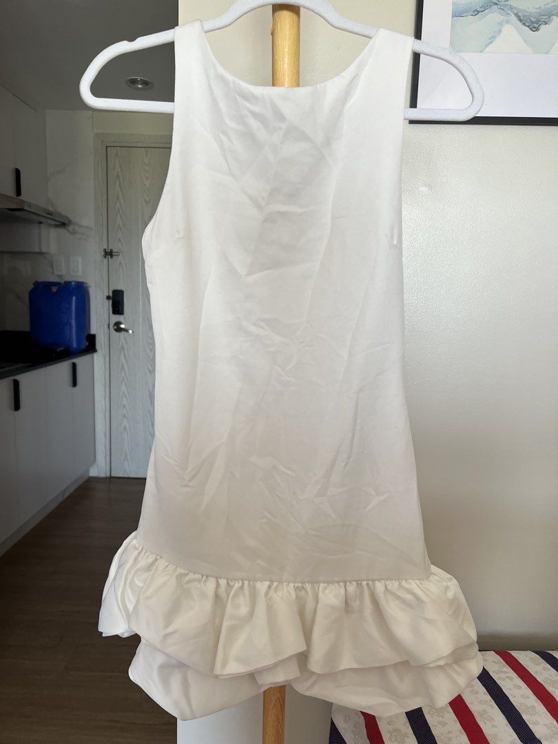 Ruffle dress by clothes for breakfast (Category: Dresses) located in Quezon City. Submitted by pattyyspreloved (Listing ID 1465963979, Image 1). Description: - Color: White - Style: Mini dress with fitted silhouette and playful puffy ruffled hem - Neckline: Round neck front with a chic deep V-back - Closure: Convenient concealed back zipper - Material: Smooth, comfortable fabric - Occasion: Perfect for casual outings, dates, and parties - Conditi