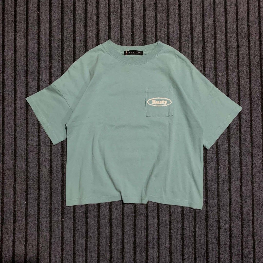Rusty Surf Supply Co. T-Shirt - Blue (Category: Shirts) located in Bulacan. Submitted by lzl_thriftfinds (Listing ID 1446494648, Image 1). Description: - Brand: Rusty - Color: Blue - Size 18W x 19L - Features: Front pocket with Rusty logo - Back graphic: Smiley face with text 'Rusty Surf Supply Co. Since 1985 Surfboards' - Ideal for: Casual wear.