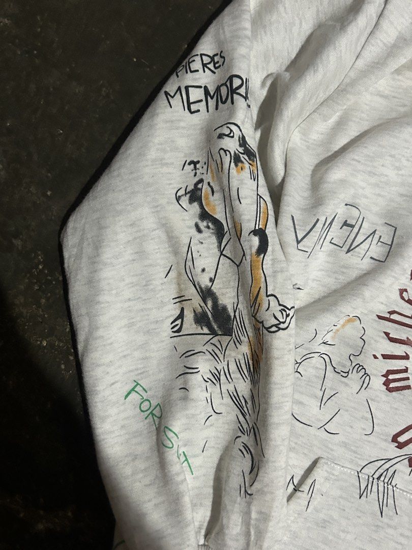 Saint Michael Jesus Print Hoodie (Category: Hoodies) located in Cabuyao City. Submitted by hachikuro (Listing ID 1466039799, Image 3). Description: - Design: Grey pullover hoodie with all-over hand-drawn style illustrations and graphic text - Back Details: Large 'SAINT' lettering paired with an angel graphic 25.5 x27 issue one penhole naka post na po and no tags.