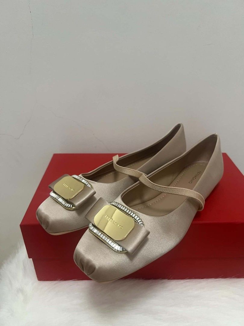 Salvatore Ferragamo Vara Ballet Flats (Category: Sneakers & Footwear) located in Paoay. Submitted by rvf1230 (Listing ID 1465992516, Image 3). Description: - Brand: Salvatore Ferragamo - Style: Champagne satin Mary Jane flats - Detailing: Gold metallic logo plaque framed with sparkling crystals on the toe - Fit: Comfortable elastic strap across the top for a secure fit - Inclusions: Original red storage box included - Condition: Excellent, well-m
