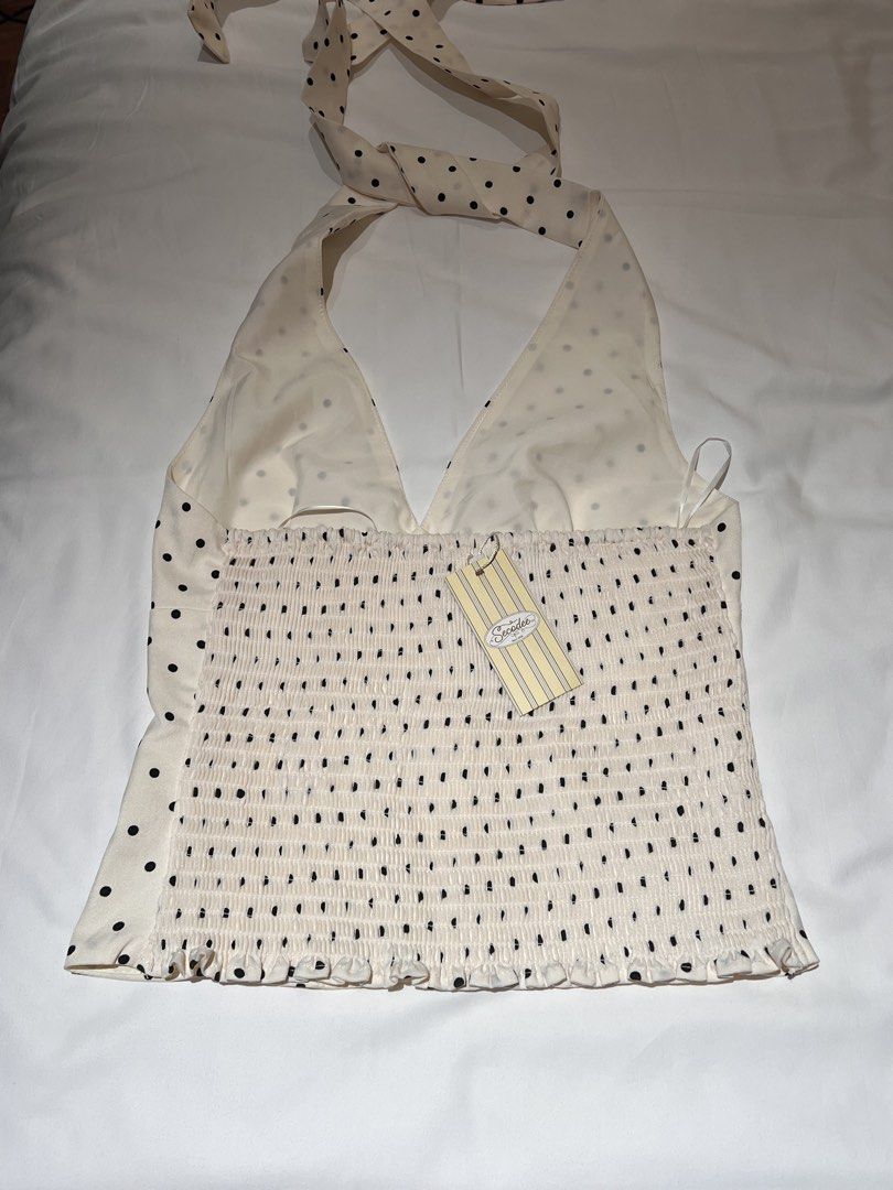 Secodee Polka Dot Halter Top (Category: Sleeveless) located in Caloocan City. Submitted by jclosetsale (Listing ID 1466121326, Image 2). Description: - Color/Pattern: Cream with black polka dots - Design: Plunging neckline & self-tie halter straps - Fit & Details: Stretchy heavy smocked back with a ruffled hem - Condition: Brand new with tag still attached.